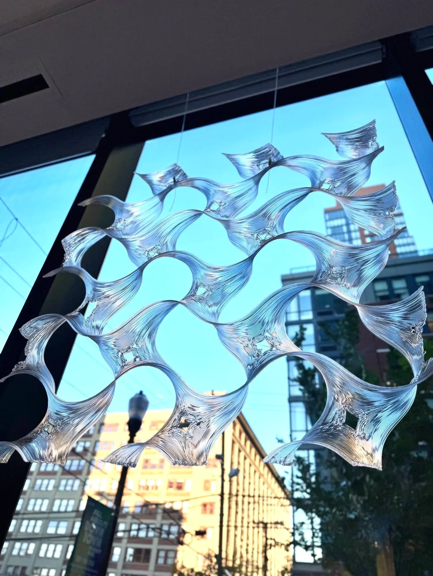 An ORIGEN sculptural piece suspended in a window